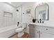 Bright bathroom features modern black hardware, a large mirror, and white tiled shower-tub at 3955 W Cindy St, Chandler, AZ 85226