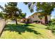 Expansive backyard with green lawn, patio, pool, and established trees for shade at 4145 W Banff Ln, Phoenix, AZ 85053