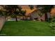 A lush green lawn leads up to a covered patio and tranquil pool area at 4145 W Banff Ln, Phoenix, AZ 85053
