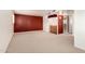 Open basement area with wet bar, red accent wall, and comfortable carpeting at 4145 W Banff Ln, Phoenix, AZ 85053