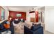 Inviting living room with wet bar, featuring blue sofa, chairs and a striking red accent wall at 4145 W Banff Ln, Phoenix, AZ 85053