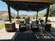 A shady back patio features an outdoor grill and seating overlooking the manicured backyard at 4277 E Blue Sage Ct, Gilbert, AZ 85297
