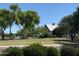 Beautiful community clubhouse surrounded by a large lawn, mature trees, and benches near a small lake at 4277 E Blue Sage Ct, Gilbert, AZ 85297