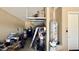 Cluttered garage with overhead storage, water heater, and various household items at 4277 E Blue Sage Ct, Gilbert, AZ 85297