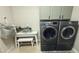 Laundry room with modern, gray front load washer and dryer beneath gray storage cabinets at 4277 E Blue Sage Ct, Gilbert, AZ 85297