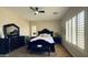Well-lit main bedroom with a dark wood furniture set, ceiling fan, and plush carpet at 4277 E Blue Sage Ct, Gilbert, AZ 85297