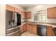 Well-lit kitchen featuring wooden cabinets, stainless steel appliances, and a double basin sink at 4682 E Redfield Rd, Gilbert, AZ 85234