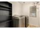 Functional laundry room with modern washer/dryer units, shelving, and natural light at 4682 E Redfield Rd, Gilbert, AZ 85234