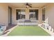 Comfortable covered back patio with lounge furniture and ceiling fan, perfect for relaxing outdoors at 4933 W Melody Ln, Laveen, AZ 85339