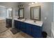 Bathroom with a blue double sink vanity, framed mirrors, and a sliding door to the bath and shower at 4933 W Melody Ln, Laveen, AZ 85339