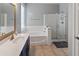 Bright bathroom featuring a soaking tub, glass-enclosed shower, and a vanity with golden hardware at 4933 W Melody Ln, Laveen, AZ 85339