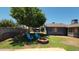 Lush backyard with a fire pit, seating area, and mature trees at 5539 E Dragoon Ave, Mesa, AZ 85206