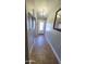 Bright hallway with tiled floors, leading to a white front door and framed artwork adorning the walls at 5539 E Dragoon Ave, Mesa, AZ 85206