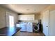 Well-equipped laundry room with multiple modern washers and dryers, storage cabinets, and a convenient folding table at 5539 E Dragoon Ave, Mesa, AZ 85206