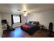 Spacious bedroom with dark wood floors, a ceiling fan, exercise bike, and bench at 5539 E Dragoon Ave, Mesa, AZ 85206