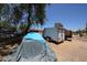 Large backyard with trees, trailers and a car covered with a blue tarp at 6249 E Larkspur Dr, Scottsdale, AZ 85254