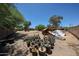 Large backyard featuring several potted plants, a lawnmower, and gravel landscaping at 6249 E Larkspur Dr, Scottsdale, AZ 85254