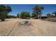 View of the spacious backyard, featuring sparse trees and gravel landscaping at 6249 E Larkspur Dr, Scottsdale, AZ 85254
