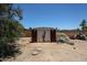 Backyard shed featuring double doors, overhead lighting, and gravel landscaping at 6249 E Larkspur Dr, Scottsdale, AZ 85254