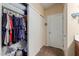 Walk-in closet with clothes, shelves and additional storage with access to the bathroom at 6319 W Mercer Ln, Glendale, AZ 85304