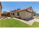 Home exterior showing a two-car garage, mature landscape, and covered front porch at 6319 W Mercer Ln, Glendale, AZ 85304