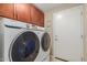 Bright laundry room features Samsung washer and dryer and ample cabinet storage at 6319 W Mercer Ln, Glendale, AZ 85304