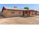 Single-story home featuring a covered porch and a low, chain-link fence around the backyard at 6521 W Flower St, Phoenix, AZ 85033