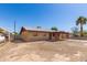 Single-story home featuring a covered porch and a low, chain-link fence around the backyard at 6521 W Flower St, Phoenix, AZ 85033