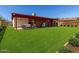 Spacious backyard with a covered patio and lush green lawn, ideal for outdoor living at 6521 W Flower St, Phoenix, AZ 85033