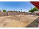 A spacious backyard featuring partial fencing and a covered patio at 6521 W Flower St, Phoenix, AZ 85033