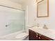 Traditional bathroom featuring a shower-tub combo, toilet, and a wood-trimmed vanity with a white countertop at 6521 W Flower St, Phoenix, AZ 85033