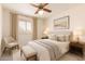 Charming bedroom with cozy decor, including a ceiling fan and a window for natural light, creating a welcoming space at 6521 W Flower St, Phoenix, AZ 85033