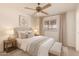 Relaxing bedroom with plush bedding, a ceiling fan, and a window for natural light, creating a peaceful retreat at 6521 W Flower St, Phoenix, AZ 85033
