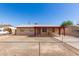 Single-story home featuring a covered porch and a low, chain-link fence around the front yard at 6521 W Flower St, Phoenix, AZ 85033