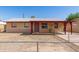 Cozy single-story home featuring a covered porch and a low, chain-link fence around the front yard at 6521 W Flower St, Phoenix, AZ 85033