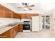 Traditional kitchen featuring wood cabinets, white appliances, and tiled floor open to a dining area at 6521 W Flower St, Phoenix, AZ 85033