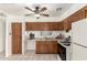 Staged kitchen with wooden cabinets, tiled floors, and standard appliances at 6521 W Flower St, Phoenix, AZ 85033