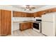 A traditional kitchen with wood cabinets, tile flooring, and white appliances, ready for meal preparation at 6521 W Flower St, Phoenix, AZ 85033