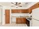 Kitchen with wooden cabinets, tiled floors, and standard appliances at 6521 W Flower St, Phoenix, AZ 85033