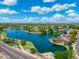 Scenic aerial view of a community with a lake, water features, and tree-lined streets at 6967 W Irma Ln, Glendale, AZ 85308