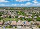 Neighborhood aerial view with green spaces, mature trees, and homes with solar panels at 6967 W Irma Ln, Glendale, AZ 85308