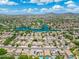 Gorgeous aerial view of the neighborhood featuring a lake, green space, and mountain backdrop at 6967 W Irma Ln, Glendale, AZ 85308