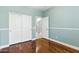 This bedroom has wood floors, a large closet, and a neutral paint color at 6967 W Irma Ln, Glendale, AZ 85308