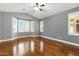 This spacious bedroom features hardwood floors, large windows, and a ceiling fan at 6967 W Irma Ln, Glendale, AZ 85308