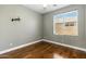 This bedroom features wood floors, a large window, and a modern ceiling fan at 6967 W Irma Ln, Glendale, AZ 85308