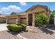 Charming home featuring a three-car garage, desert landscaping, and a welcoming front porch at 6967 W Irma Ln, Glendale, AZ 85308