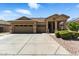 Charming home featuring a three-car garage, desert landscaping, and a welcoming front porch at 6967 W Irma Ln, Glendale, AZ 85308