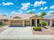 Charming home featuring a three-car garage, desert landscaping, and a welcoming front porch at 6967 W Irma Ln, Glendale, AZ 85308