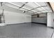 Spacious garage with epoxy flooring, built-in storage cabinets, and ample room for parking and projects at 6967 W Irma Ln, Glendale, AZ 85308