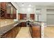 Elegant kitchen features dark wood cabinets, granite countertops, and stainless steel appliances at 6967 W Irma Ln, Glendale, AZ 85308